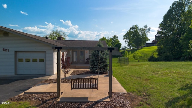 view of yard featuring an attached garage and aphalt driveway