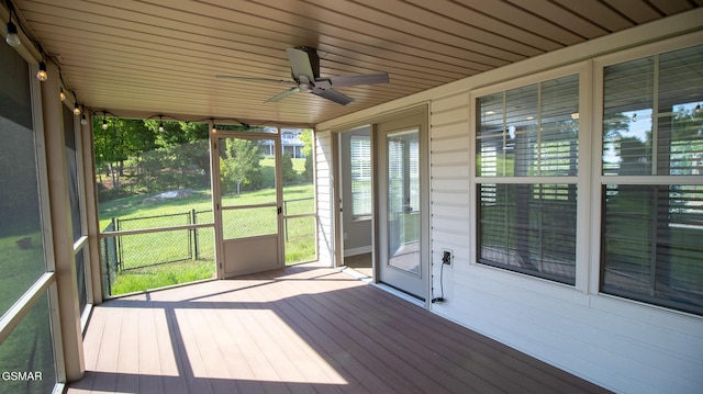 unfurnished sunroom with ceiling fan