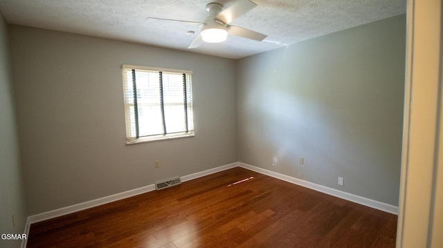 unfurnished room with a ceiling fan, a textured ceiling, baseboards, visible vents, and dark wood-type flooring