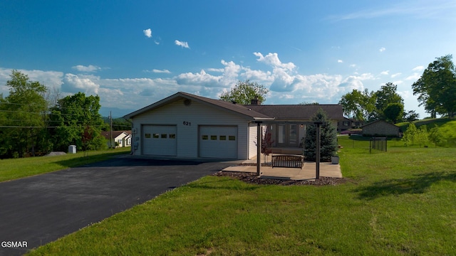 single story home featuring driveway, a front lawn, and an attached garage