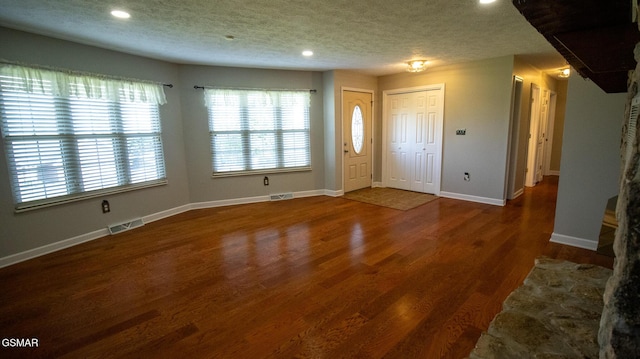 foyer featuring a textured ceiling, visible vents, and recessed lighting