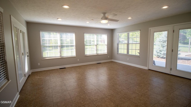 unfurnished room with a textured ceiling, a healthy amount of sunlight, and recessed lighting