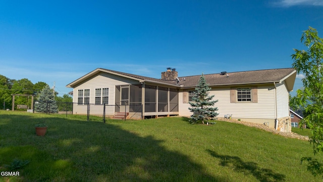 back of house with a chimney, a yard, a sunroom, and fence