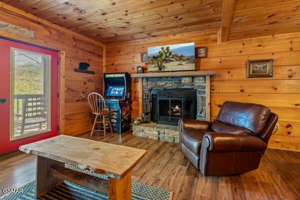 living room featuring wood ceiling, wood finished floors, wooden walls, and a fireplace