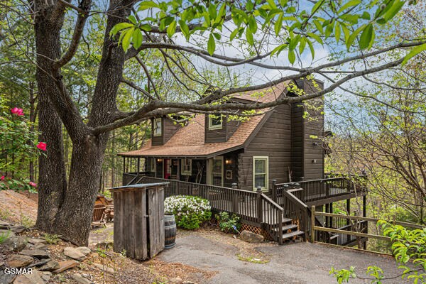 rear view of house with a deck and a shingled roof