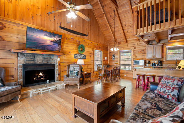 living area featuring hardwood / wood-style floors, plenty of natural light, wooden walls, and wood ceiling