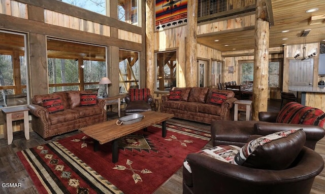 living room with an inviting chandelier, wood ceiling, a towering ceiling, and wood-type flooring