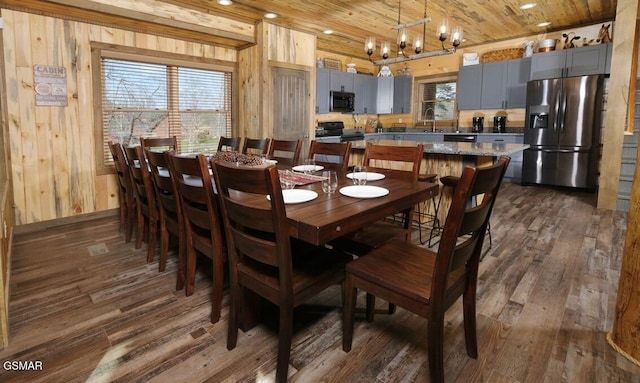 dining space featuring wood ceiling, wooden walls, a chandelier, and hardwood / wood-style floors