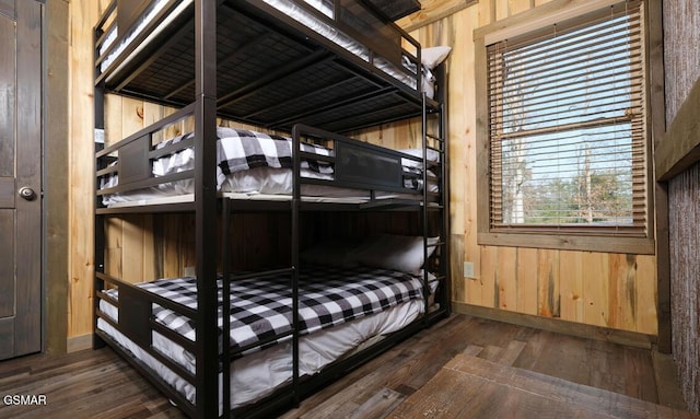 bedroom featuring dark wood-type flooring and wood walls