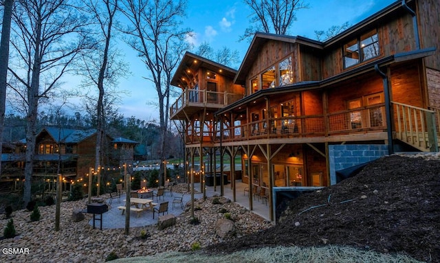 rear view of house featuring a patio area, an outdoor fire pit, and a balcony