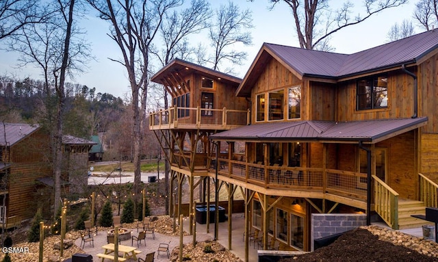 back of house with a deck and a patio