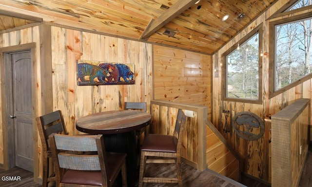 dining room featuring hardwood / wood-style flooring, wood ceiling, wood walls, and lofted ceiling with beams