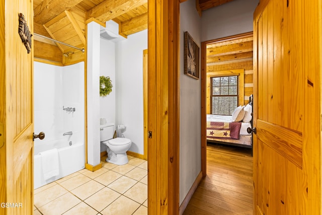 full bath with beamed ceiling, toilet, shower / washtub combination, tile patterned flooring, and baseboards