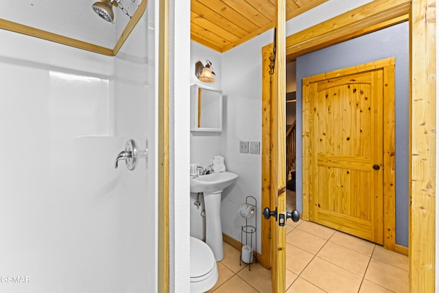 bathroom with toilet, a sink, wooden ceiling, tile patterned flooring, and baseboards