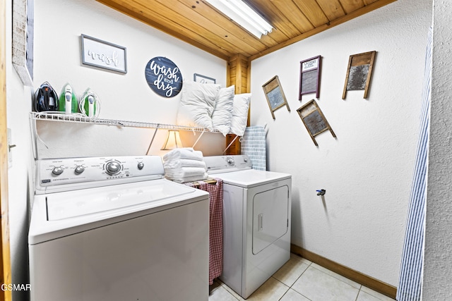 laundry room with baseboards, laundry area, light tile patterned flooring, wooden ceiling, and washing machine and dryer