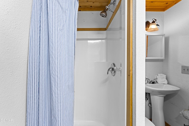 bathroom featuring wooden ceiling and a shower stall