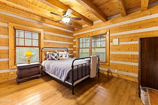 bedroom featuring wooden ceiling, wooden walls, multiple windows, and wood finished floors