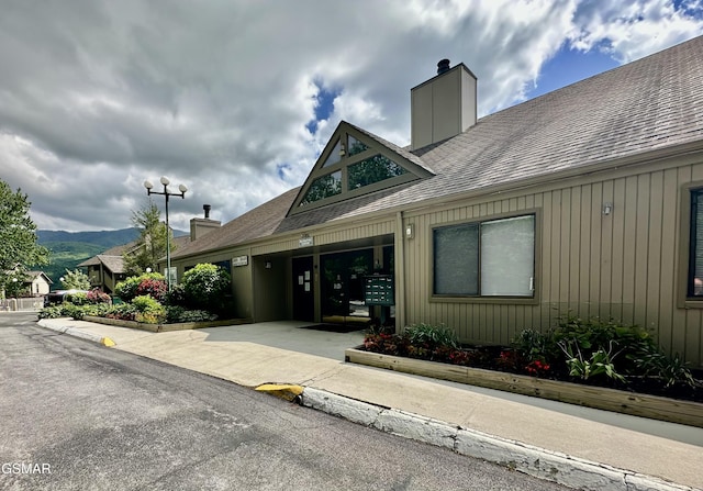 3710 Weber Rd Unit E306, Gatlinburg, TN 37738 - doorway to property with a chimney, roof with shingles, a mountain view, and concrete driveway