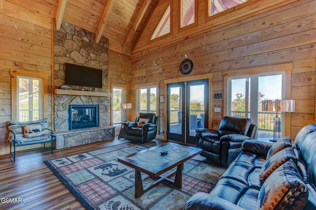 living room with wooden ceiling, high vaulted ceiling, wooden walls, a fireplace, and beam ceiling