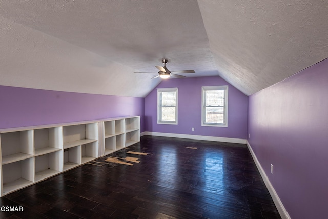 additional living space featuring vaulted ceiling, ceiling fan, a textured ceiling, and dark hardwood / wood-style floors