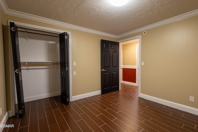 unfurnished bedroom featuring a textured ceiling, a closet, ornamental molding, and dark hardwood / wood-style floors