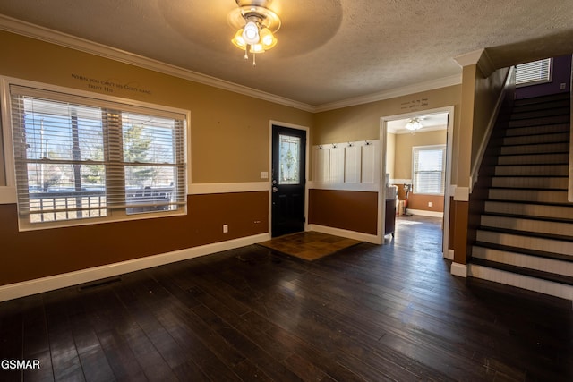 foyer with ceiling fan, dark wood-type flooring, crown molding, and a textured ceiling