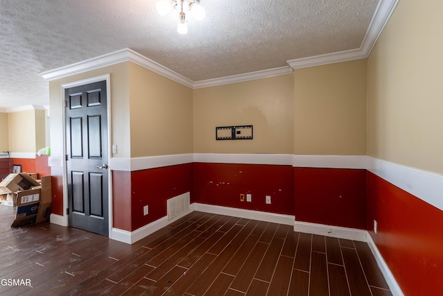 spare room featuring a textured ceiling, ornamental molding, and dark hardwood / wood-style floors