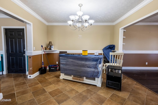 dining area featuring a textured ceiling, ornamental molding, and a chandelier