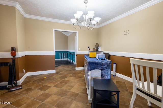 dining space with a textured ceiling, ornamental molding, and a notable chandelier