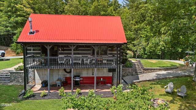 4091 Camp Hollow Rd, Sevierville, TN 37876 - view of front facade featuring a front lawn, a metal roof, a wooden deck, and a patio area