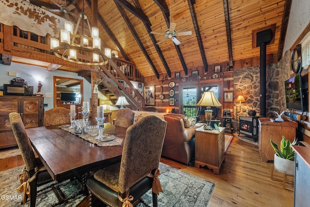 4091 Camp Hollow Rd, Sevierville, TN 37876 - dining space featuring a wooden ceiling with exposed beams, a wood stove, stairs, high vaulted ceiling, and light wood-style floors