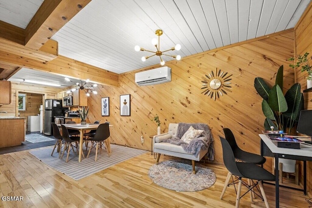 dining area with a wall mounted AC, beam ceiling, an inviting chandelier, light hardwood / wood-style floors, and wood walls