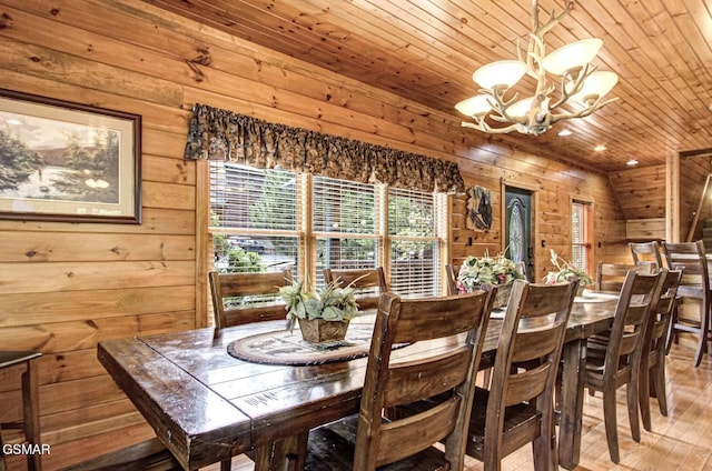 dining space with wood ceiling, vaulted ceiling, wooden walls, a notable chandelier, and hardwood / wood-style floors