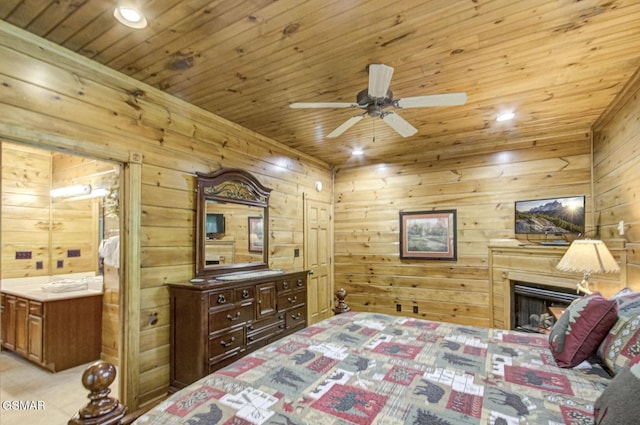 carpeted bedroom with ensuite bath, wood walls, ceiling fan, and wood ceiling