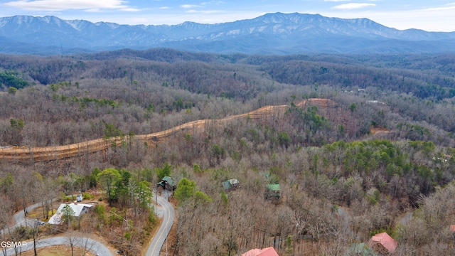 aerial view featuring a wooded view and a mountain view