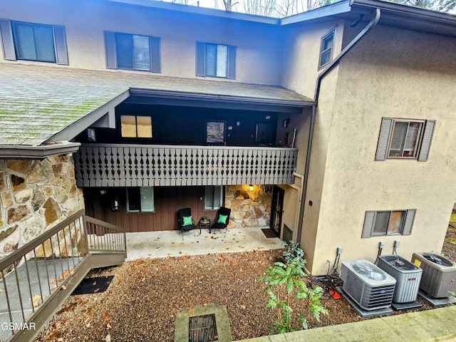 rear view of property with cooling unit and a patio