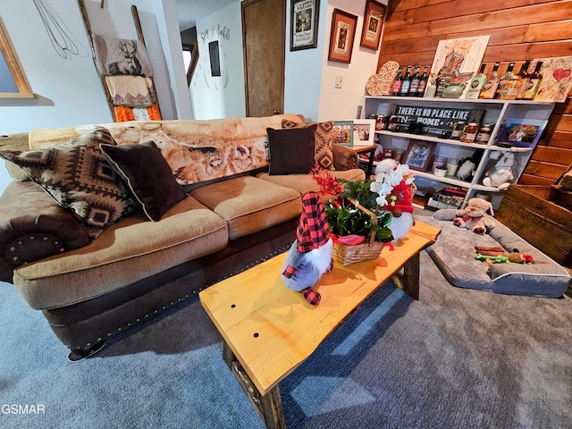 living room featuring carpet floors and wooden walls