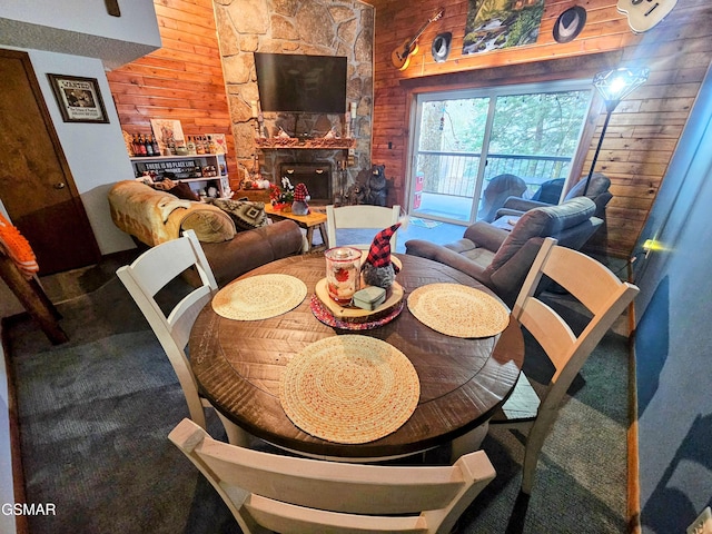 dining space with wood walls and a fireplace