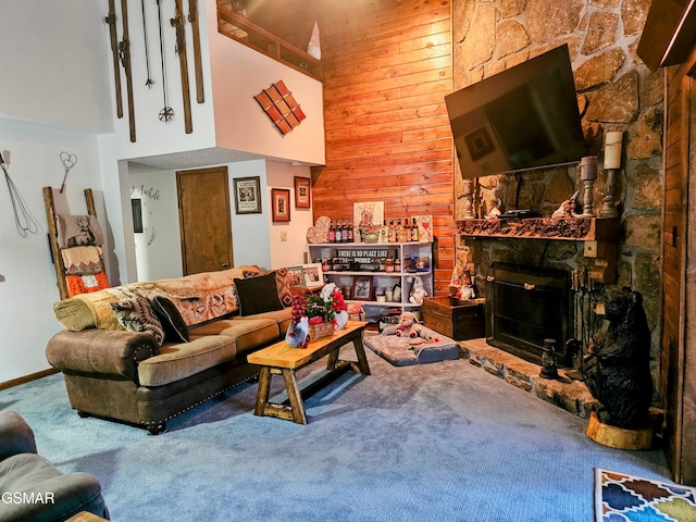 living room featuring carpet, wood walls, a fireplace, and a high ceiling