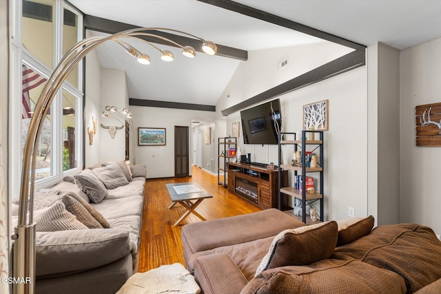 living room featuring wood-type flooring and lofted ceiling with beams