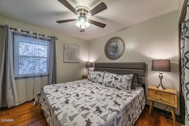 bedroom with dark hardwood / wood-style flooring and ceiling fan