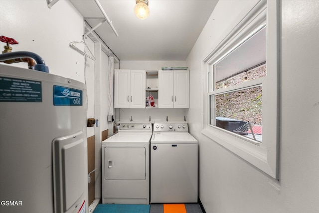 washroom featuring cabinets, electric water heater, and washer and clothes dryer