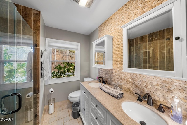 bathroom with vanity, toilet, an enclosed shower, and backsplash