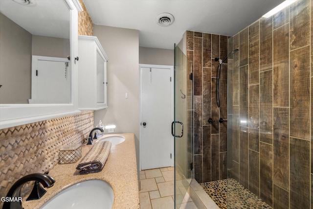 bathroom with vanity, decorative backsplash, and a shower with shower door