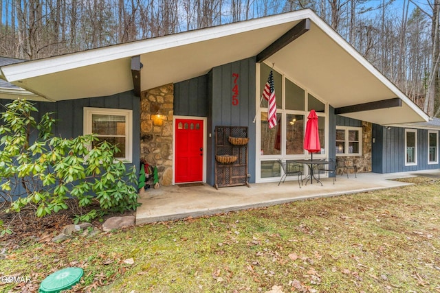 property entrance featuring stone siding and board and batten siding