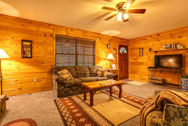 carpeted living room featuring ceiling fan and a textured ceiling