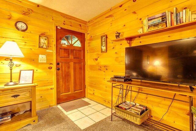 entryway with tile patterned floors and wood walls