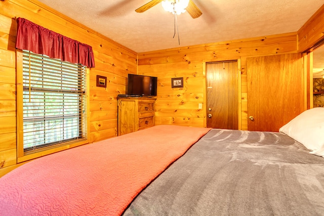 unfurnished bedroom with ceiling fan, carpet floors, a textured ceiling, and wooden walls