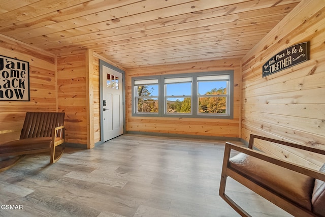 sitting room featuring hardwood / wood-style flooring, vaulted ceiling, wooden ceiling, and wood walls