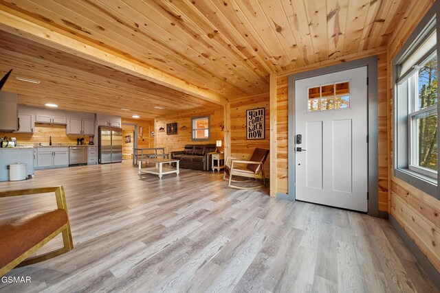 foyer with wooden ceiling, sink, wooden walls, and light hardwood / wood-style flooring